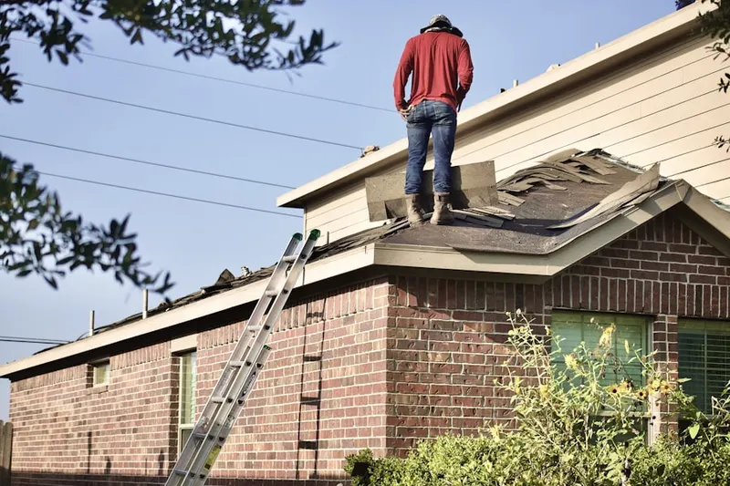 Professional roofer working on a residential roof in Holley